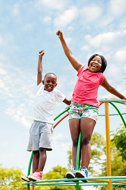 istock African kids shouting and raising hands in park. 465478932