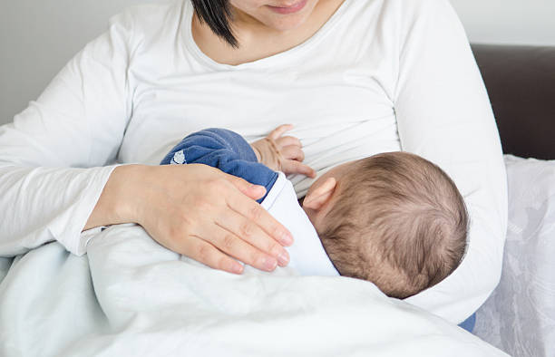 A woman breastfeeding her baby stock photo