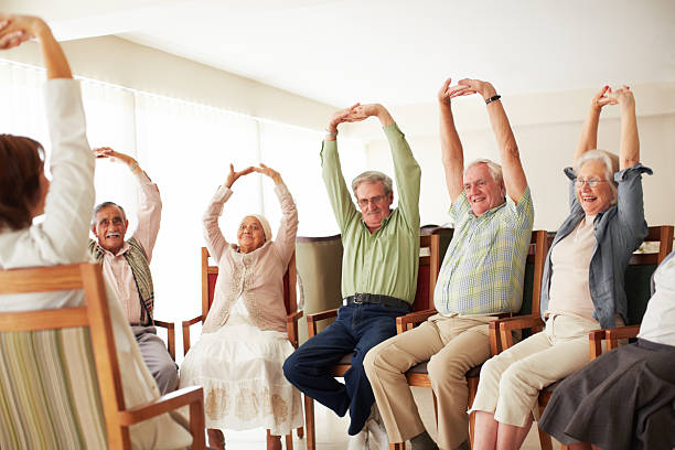 istock Elderly people in chairs stretch arms 465480235
