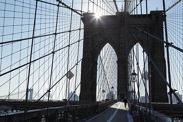 istock Man jogging across the Brooklyn Bridge as the sun rises 465480580