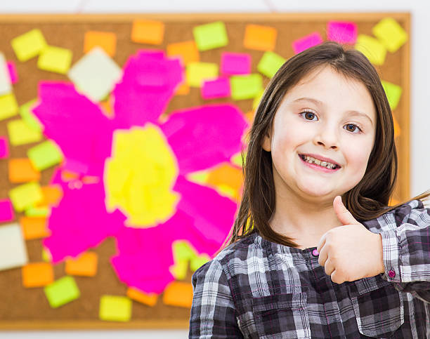 istock Child in front on table of notes with flower figure 465482765