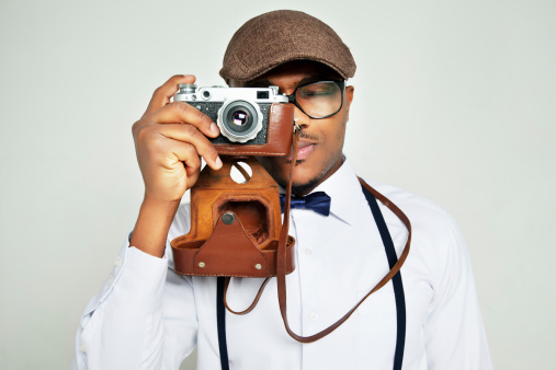 Portrait of a stylish young man with old photocamera