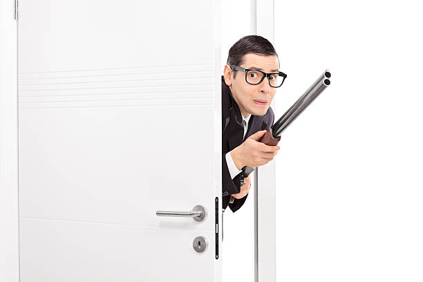 istock Terrified man with rifle entering a room 465484672
