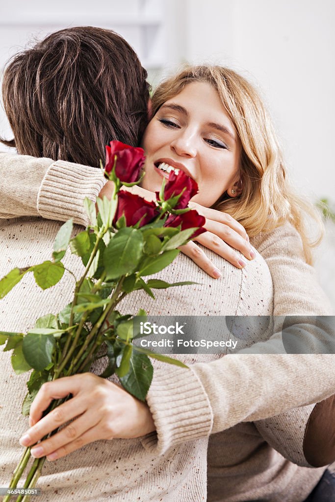Young man giving a red rose to his girlfriend Young man giving a red rose to his girlfriend. Adult Stock Photo