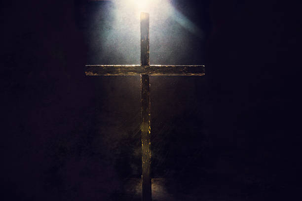 oscuridad cruce con luz de varilla - crucifix fotografías e imágenes de stock