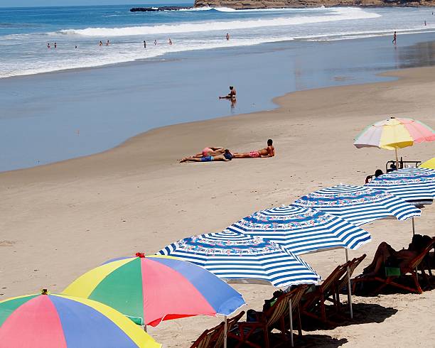 People swimming, resting and relaxing in the sun, Montañita, Ecuador Montañita, Ecuador - March 3, 2015: People swimming, resting and relaxing on the beach and in the water in the sun at Montañita, Ecuador montanita ecuador stock pictures, royalty-free photos & images
