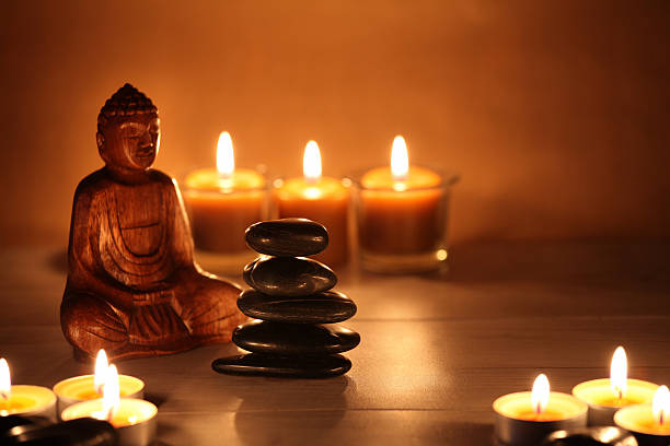 équilibrer les pierres zen avec des bougies et un bouddha en - tea light votive candle candle candlelight photos et images de collection