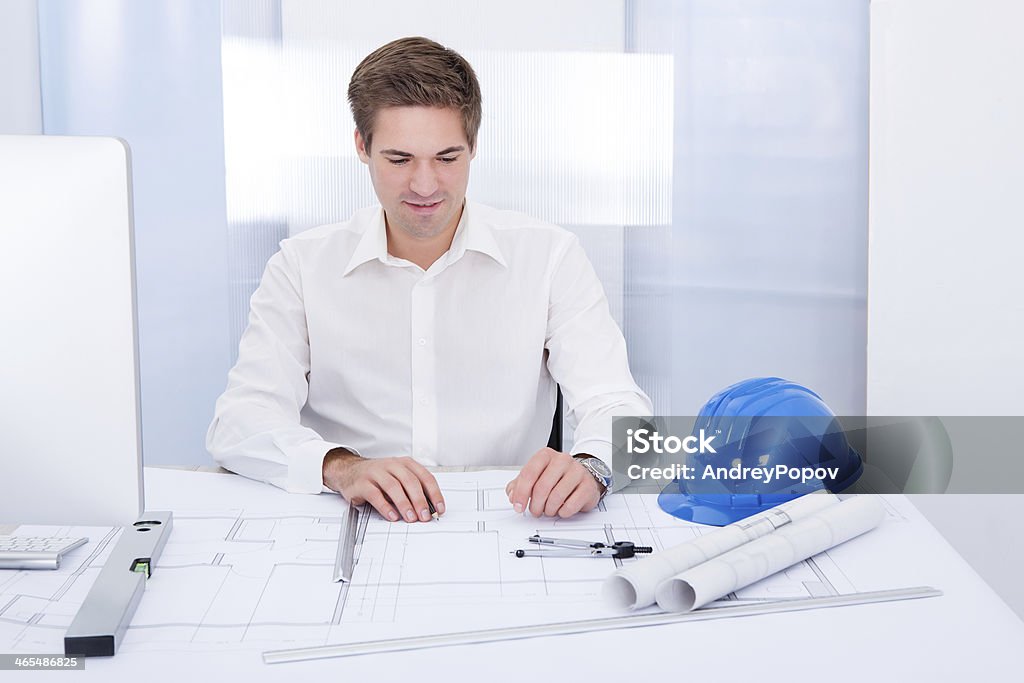 Young Architect Drawing Plan On Blueprint Portrait Of A Young Architect Drawing Plan On Blueprint Adult Stock Photo