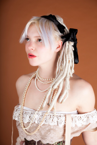 A sensual blonde lady wearing pearls and an off-the-shoulder dress.