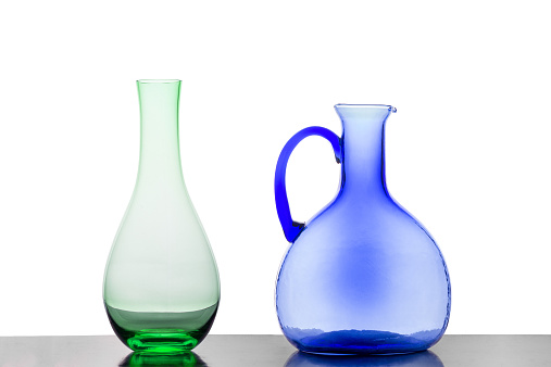 A Green Vase and a Blue Jug Against a White Background