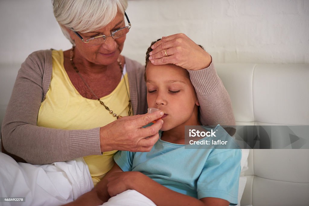 Medicine will help with the sniffles Shot of a caring grandmother taking care of her sick grandson at homehttp://195.154.178.81/DATA/istock_collage/a4/shoots/785194.jpg 2015 Stock Photo