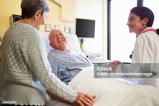 Doctora Hablando Con Pareja Senior En Hospital Habitación Foto de stock y más banco de imágenes de Paciente