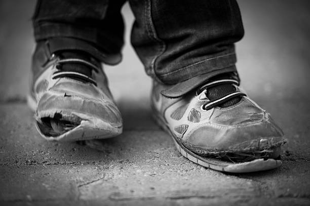 child shoes Village boy in Turkey wearing pair of old shoes. midyat photos stock pictures, royalty-free photos & images