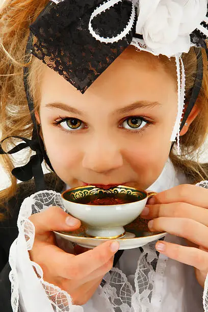 Beautiful Tween Girl in Cosplay Fashion Sipping Tea
