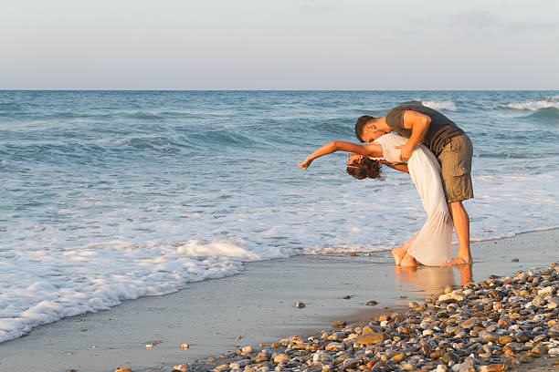 istock Young couple enjoys walking on a hazy beach at dusk 465498616