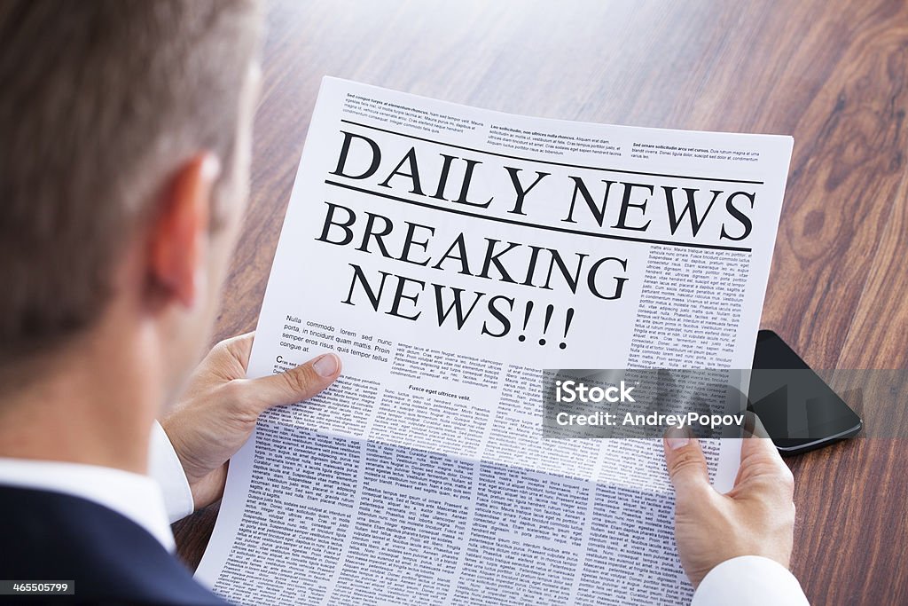 Young Businessman Reading Breaking News Young Businessman Reading Breaking News On Newspaper Newspaper Stock Photo