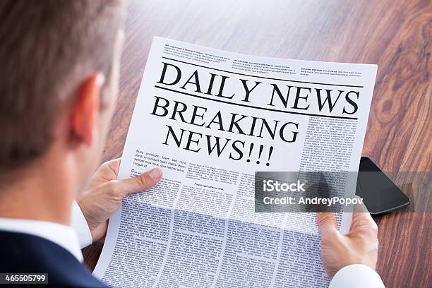 Young Businessman Reading Breaking News Stock Photo - Download Image Now - Newspaper, Reading, Men
