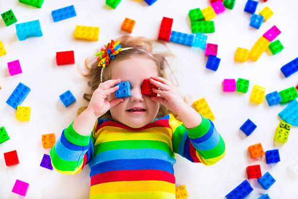 istock A little girl playing with rainbow plastic blocks 465509110