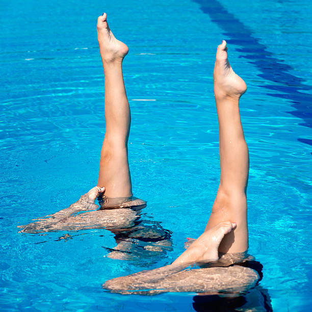 istock Two synchronized female swimmers with their feet pointed up 465510345