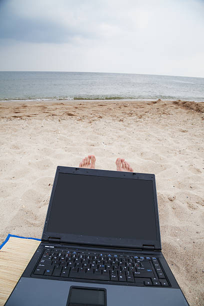 istock lying on the beach with a laptop 465513015