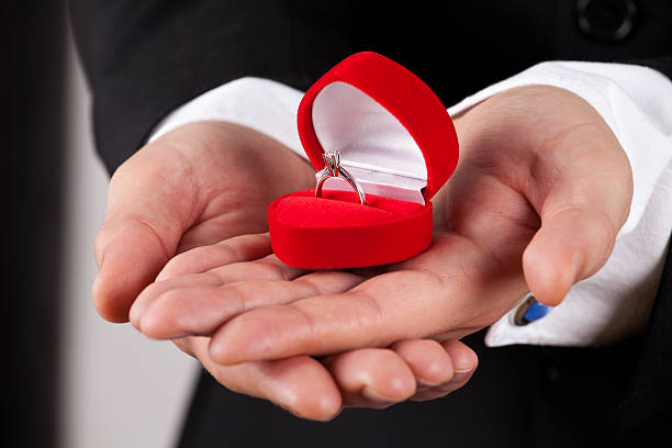 istock Man in suit holding engagement ring 465515807
