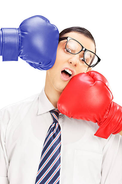istock Young man with glasses punched by two boxing gloves 465517249