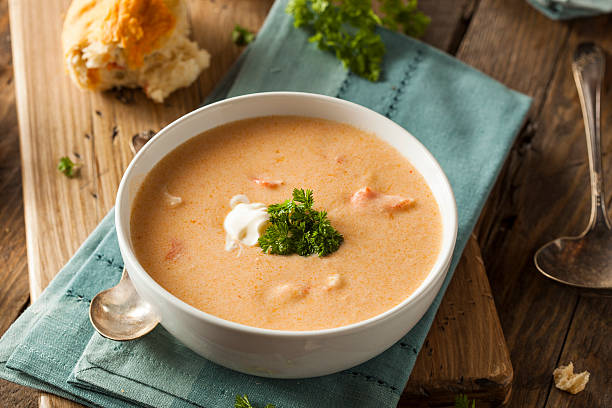 Homemade lobster bisque soup with a roll and garnish Homemade Lobster Bisque Soup with Cream and Parsley lobster seafood photos stock pictures, royalty-free photos & images