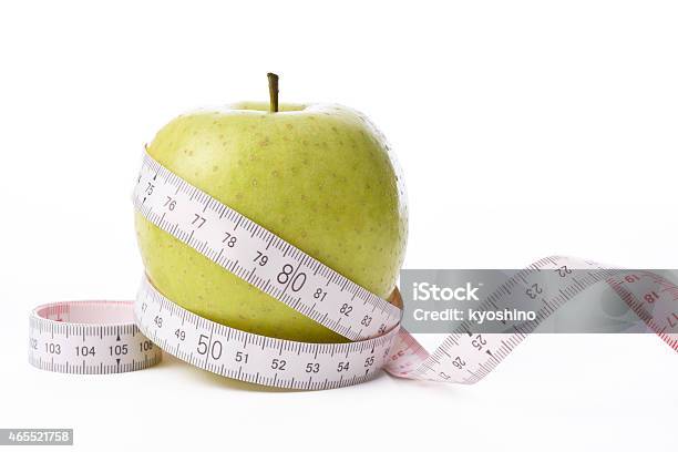 Isolated Shot Of Apple With Measurement Tape On White Background Stock Photo - Download Image Now