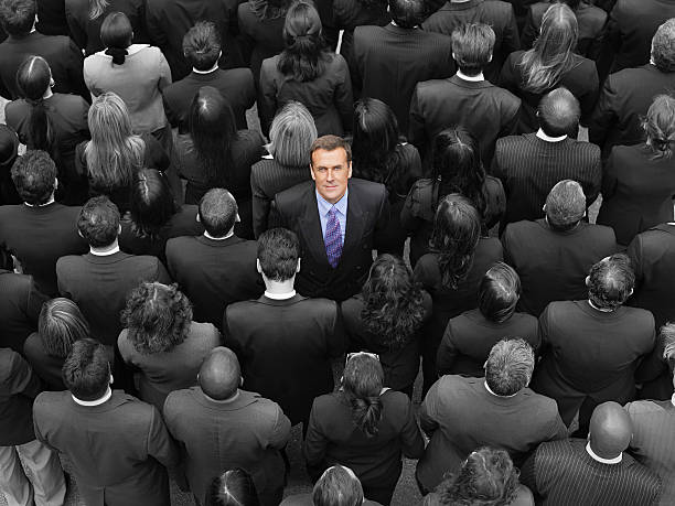 istock High angle view businessman standing amidst businesspeople 465523779