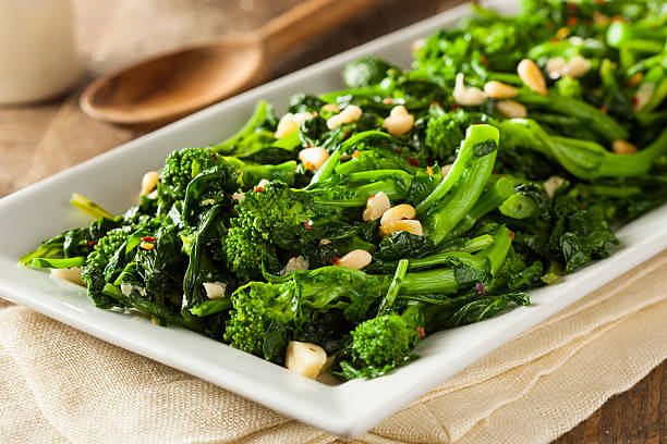 Homemade Sauteed Green Broccoli Rabe Homemade Sauteed Green Broccoli Rabe with Garlic and Nuts vitamin rich stock pictures, royalty-free photos & images