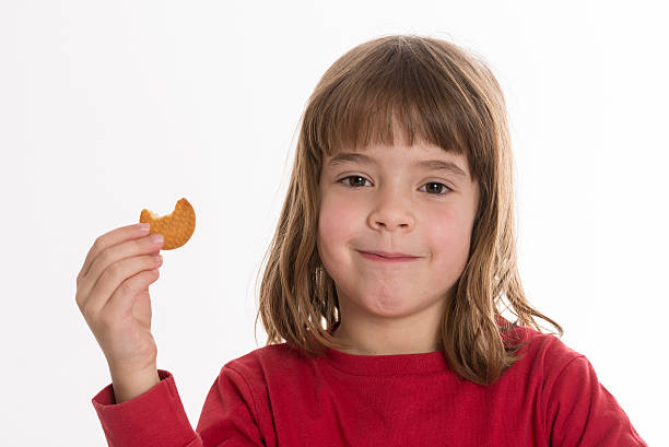 istock Little girl eating a cookie 465524628