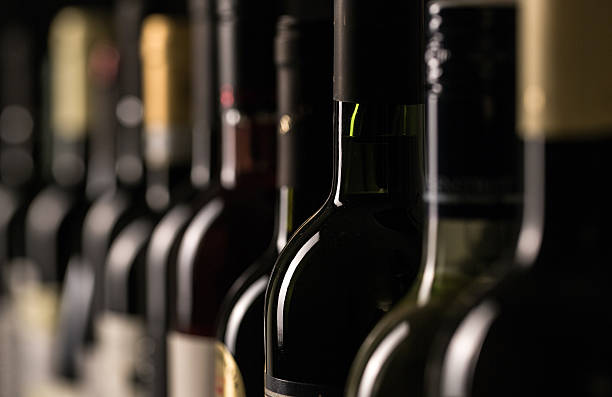 fila di bottiglie di vini d'annata - bottiglia di vino foto e immagini stock