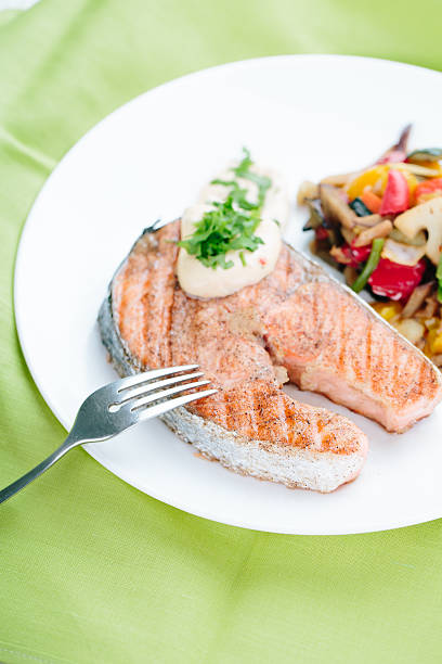 istock Grilled Salmon with Fresh vegetables on green background 465526572