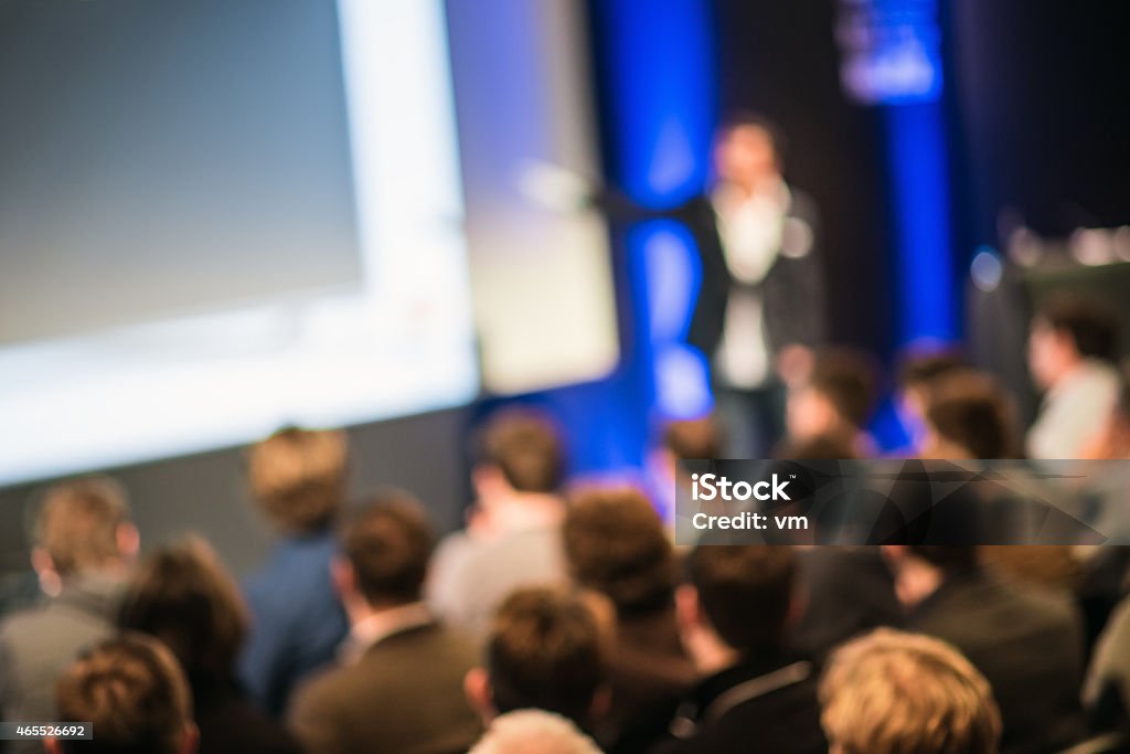 Large Group of People Listening to a Presentation Crowd in the lecture hall. Purposely blurred with a lens. Meeting Stock Photo