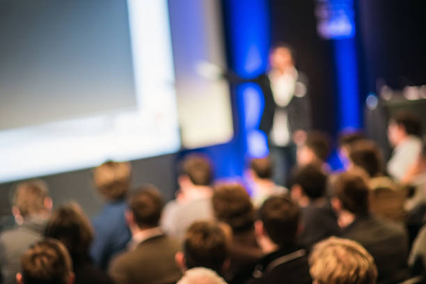 Large Group of People Listening to a Presentation Crowd in the lecture hall. Purposely blurred with a lens. business conference photos stock pictures, royalty-free photos & images