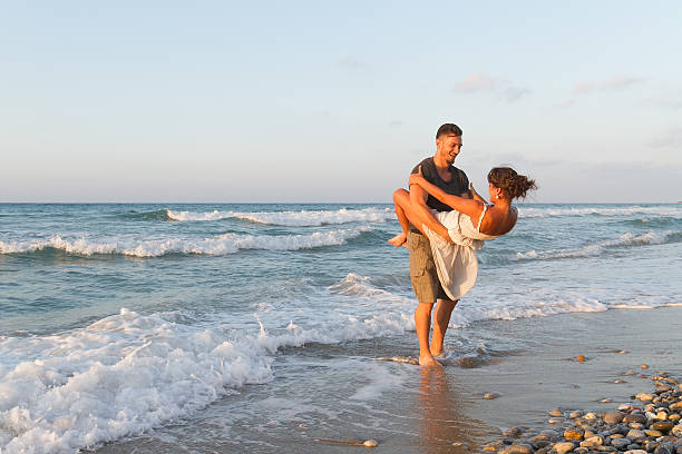 istock Young couple enjoys walking on a hazy beach at dusk 465527254