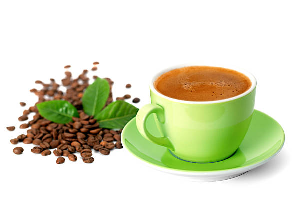 Cup of coffee with eyes next to the coffee beans on green background.