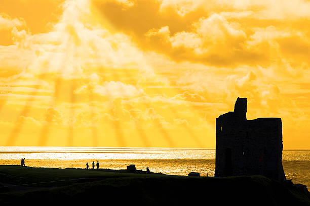 tourists at ballybunion castle at sunset stock photo