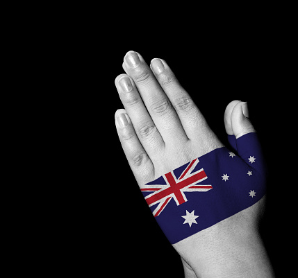 Hands folded in prayer - Australia flag painted on hands - Digitally generated