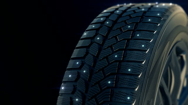 Car studded winter tyre wheel rotate on camera in motion