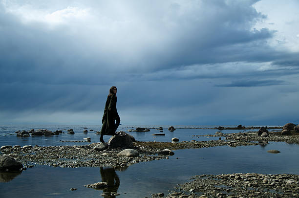 istock girl on a rocky shore 465530090