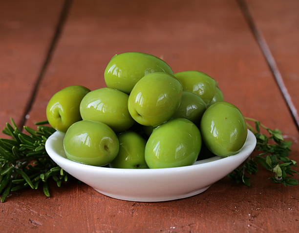 istock green marinated olives in  bowl on a wooden table 465530143