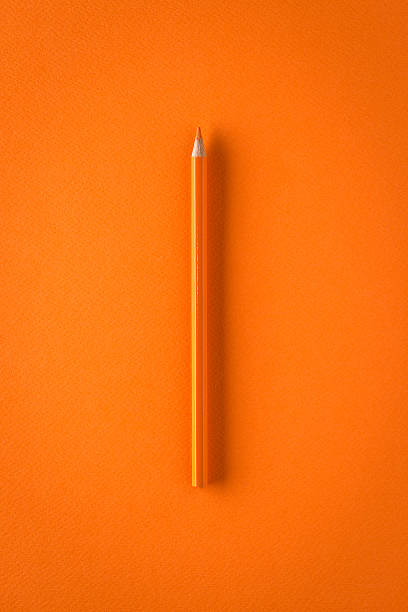 istock Orange crayon on orange paper, minimalist still life 465530854