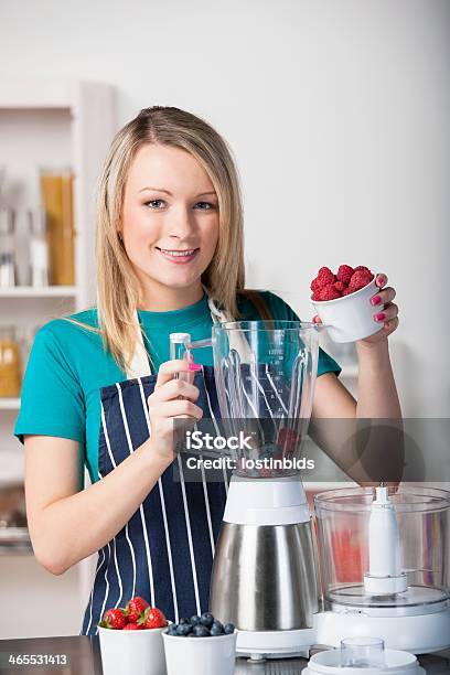 Photo libre de droit de Jeune Femme Caucasien Préparer Fruits Frais banque d'images et plus d'images libres de droit de Cuisine - Cuisine, Femmes, Milk-shake