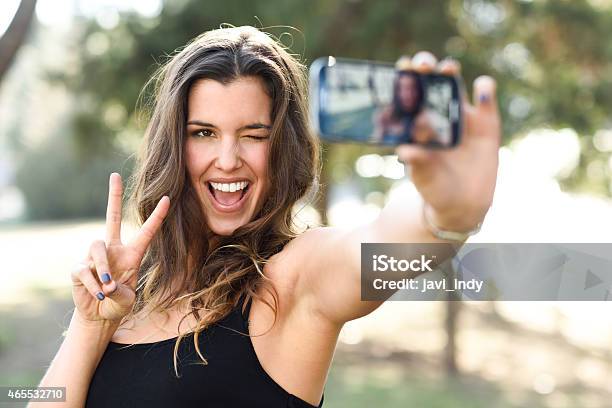 Young Woman Taking Selfie In Park With Phone Stock Photo - Download Image Now - 2015, Adult, Adults Only