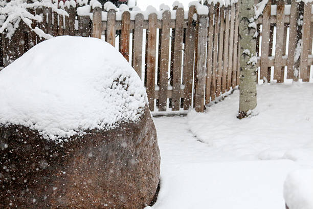 istock Snow Cover on a Landscaping Boulder and Fence 465533406