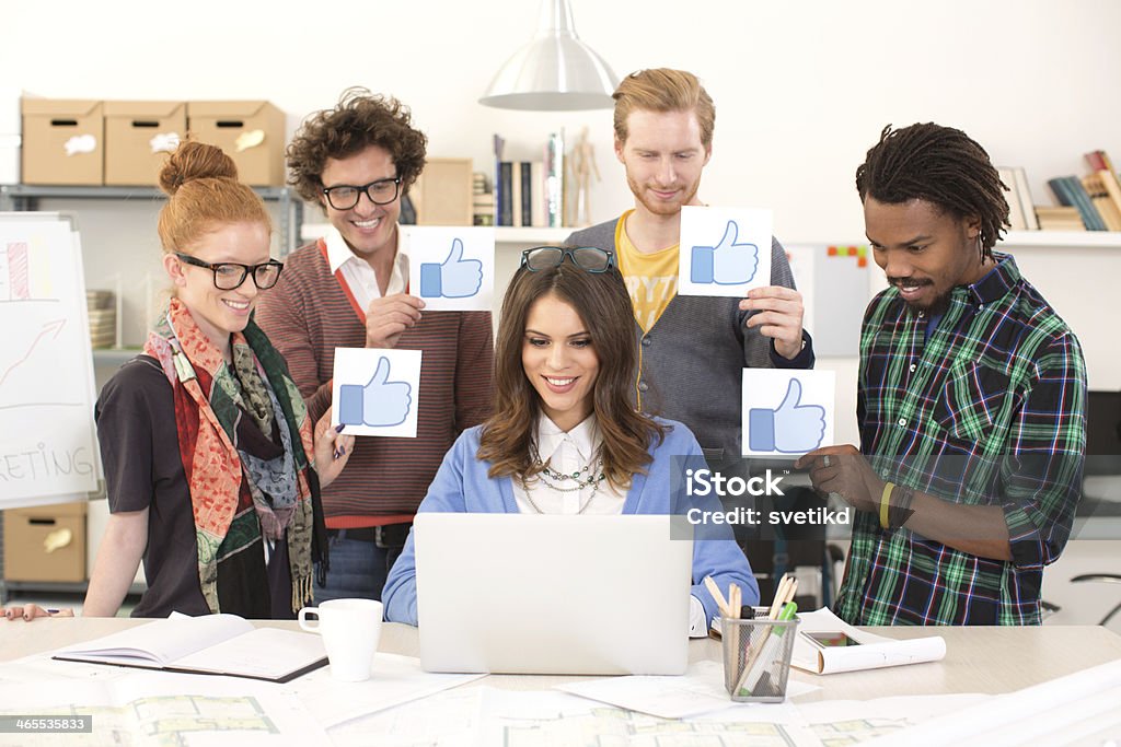 Friends like it. Group of young people standing by woman using laptop and holding thumb up signs. Social media concept. Admiration Stock Photo