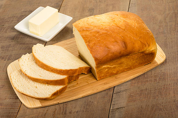 miche de pain tranché avec du beurre assiette - dishware butter cutting board agriculture photos et images de collection