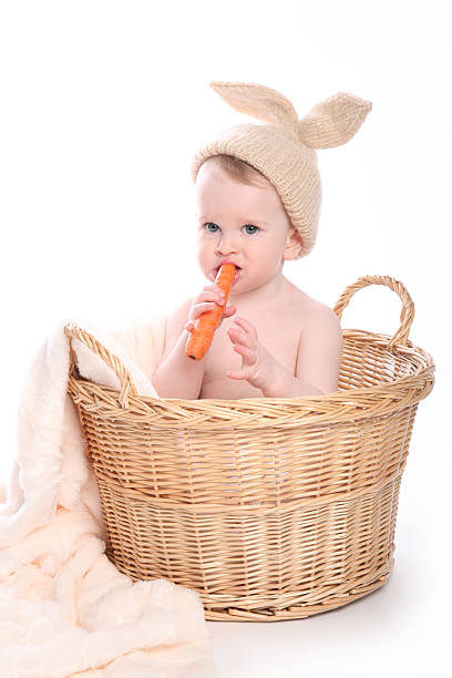 istock Cute bunny boy sitting in basket looking aside 465538125