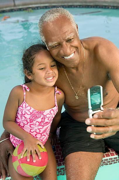 istock Grandfather and Granddaughter Playing by Pool 465543727